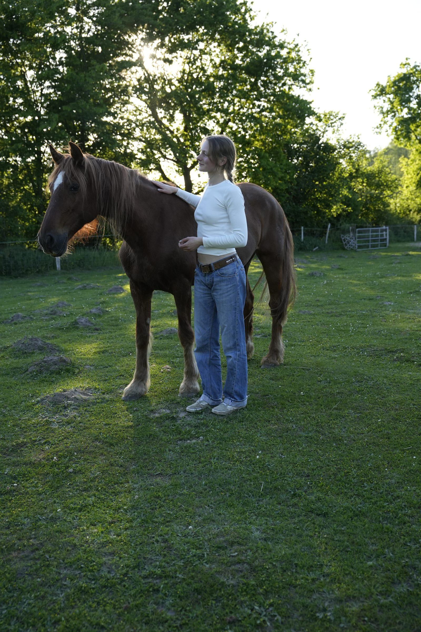 Greta bei ihrem Pferd im Abendlicht